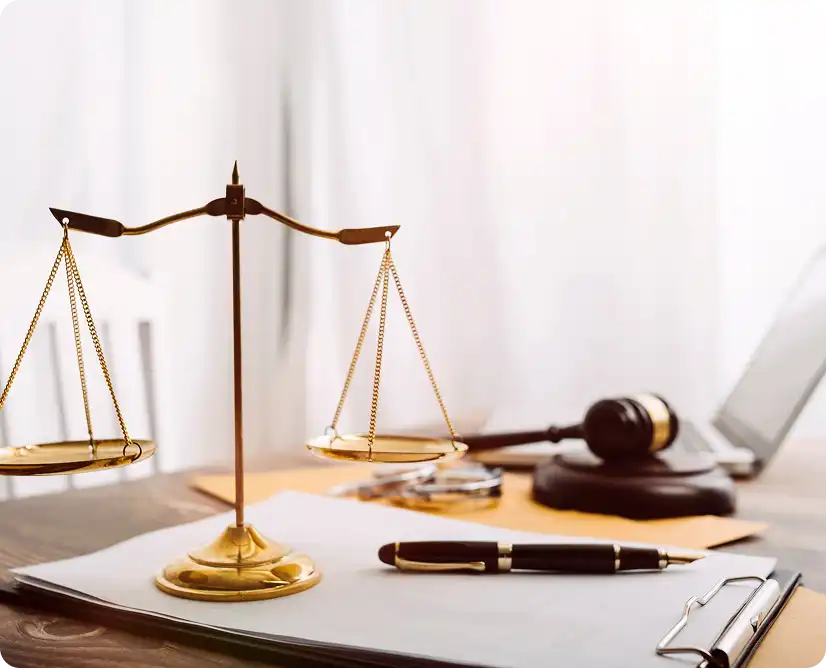 Waga sprawiedliwości i dokumenty na biurku adwokata w jasnym gabinecie.