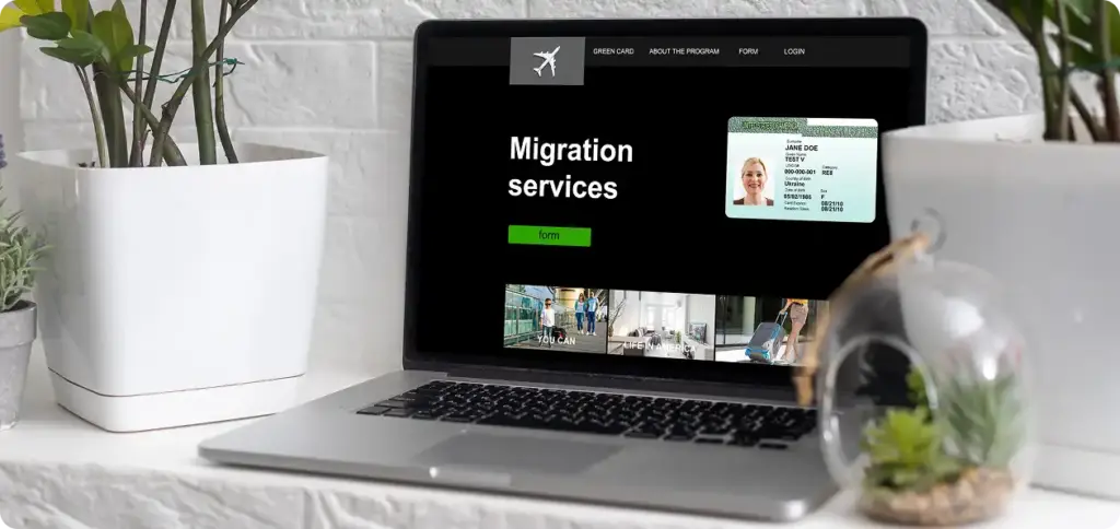 Laptop na stole z witryną służb migracyjnych i formularzem wniosku na ekranie.